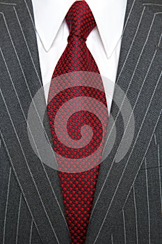 Grey pinstripe suit and red tie