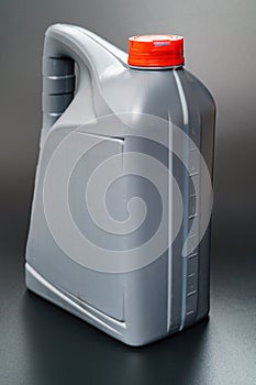 grey with a red lid canister with machine oil on a black background.