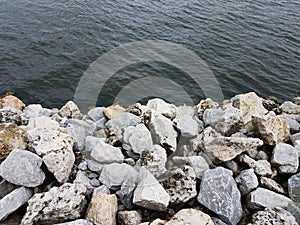 Grey rocks or stones and river or lake water