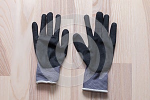 Grey rubberized work gloves on wooden surface