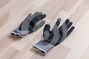 Grey rubberized work gloves on wooden surface