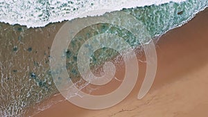 Grey sea water covering beach slow motion. Stormy ocean waves aerial top view