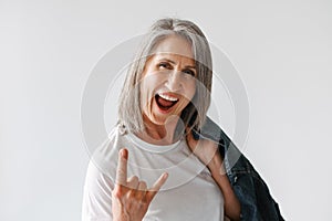 Grey senior woman gesturing while posing with denim jacket
