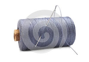 Grey sewing thread with needle on white background