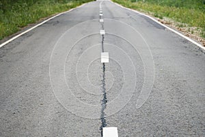 Grey shabby car asphalt road with white dividing lines