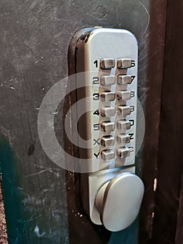 Grey silver number keypads security door locker on black door