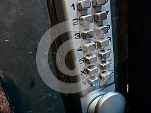 Grey silver number keypads security door locker on black door