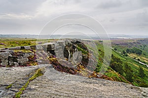 Grey skies and mist over the Derbyshire Peak District from high on Curbar Edge