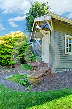 Grey small outdoor shed with backyard landscape.