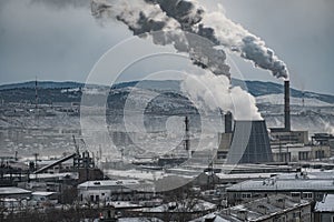 The grey smoke goes from the chimney and cooling tower in Ulan-Ude, Russia.