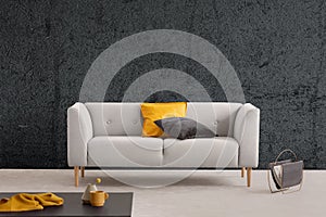 Grey sofa in living room interior with textured wall and table. Real photo