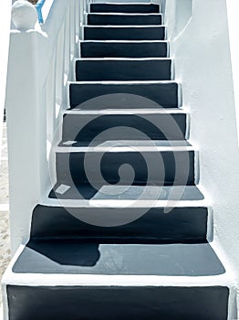 Grey stairs at whitewashed home wall at Mykonos island Cyclades Greece. Vertical