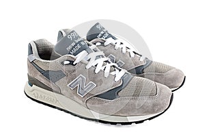 Grey suede New Balance 998 sneakers with white laces on a white studio background