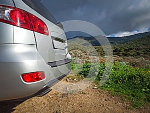 Grey SUV seen from behind under a dramatic sky in the countrysid