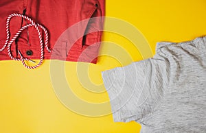 Grey tshirt and red shorts on yellow background, view from top