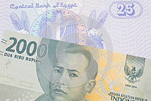 A grey two thousand Indonesian rupiah bank note paired with a blue twenty five piastre bank note from Egypt.