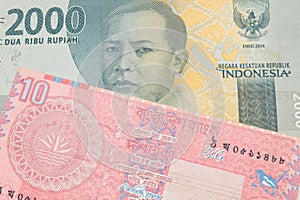 A grey two thousand Indonesian rupiah bank note paired with a red ten taka bank note from Bangladesh.