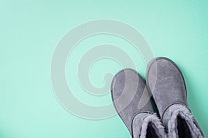Grey ugg boots on blue background. Winter concept. Christmas and new year holiday. Copy space