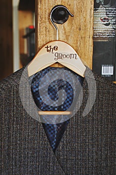 Grey waistcoat for a gentelman hangs on the peg with lettering groom photo