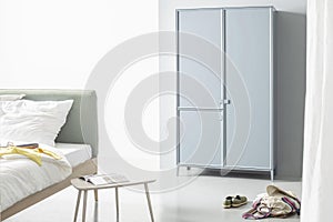 Grey wardrobe in bedroon interior.