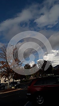 Grey and white clouds and blue sky RoxyAnn Medford Oregon cars parking photo