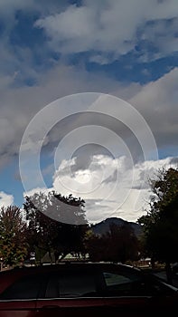 Grey and white clouds and blue sky RoxyAnn Medford Oregon cars parking photo