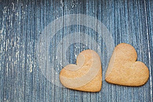 Grey wooden aged background with ginger bread biscuits. Saint valentines frame with copy space. Love and wedding photo