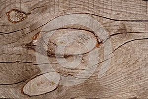 Grey wooden aged rustic board with cracks and three knots. Texture of wood plank