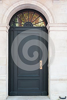 Grey wooden arch door of street restored house entrance facade classic gate