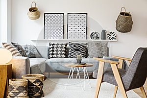 Grey wooden armchair in scandi living room interior with pattern