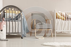 Grey wooden crib in fashionable scandinavian baby bedroom interior