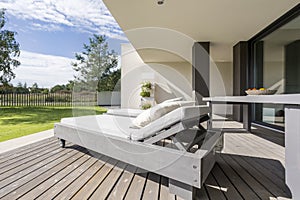 Grey wooden deckchair on patio