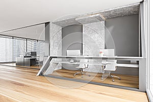 Grey and wooden reception desk with computers, business room