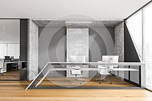 Grey and wooden reception desk with computers near window