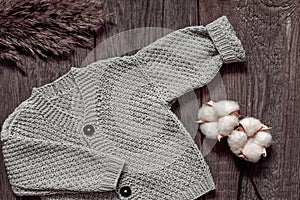 Grigio di lana lavorato maglia bambini un maglione un cotone sul di legno. Caldo manualmente body. più alto 