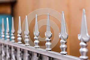 Grey wrought iron fence with repeat pattern decorations