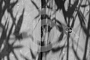 Greyscale high angle shot of two wedding rings put on each other on a wooden surface