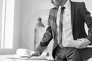 Greyscale image of a businessman or expert writing observations