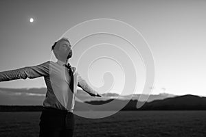 Greyscale image of businessman in white shirt and black tie stan