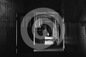 Greyscale shot of a creepy abandoned hallway inside of a building