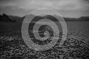 Greyscale shot of Death Valley covered with mud surrounded by beautiful mountains in the USA