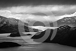 Greyscale shot of the Lake Wanaka in New Zealand under the storm clouds