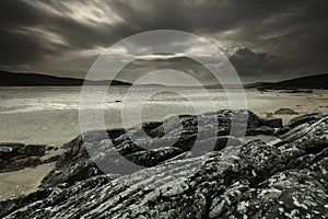 Greyscale shot of the ocean shore on a gloomy day in Harris, Outer Hebrides, Scotland