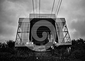 Greyscale shot of an old cableway under the dark cloudy sky