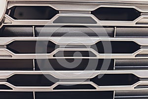 Grid of car with sunflare. Radiator grille. Metal close-up texture background. Chrome grill of big powerful engine macro
