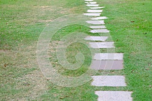 Grid cement pathway on green grass field at the park