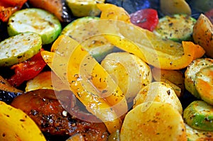 On the grid grill are fried vegetables. Potatoes, tomatoes, peppers, eggplants, cucumbers, zucchini, carrots and seasonings with o