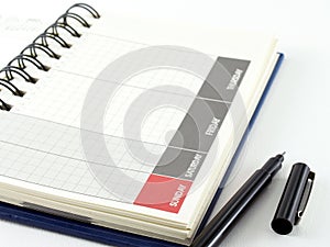 grid lines diary calendar with days name in gray and red frame and black pen on white background