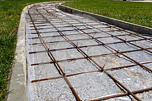 Grid made of steel rods to strengthen road in the park. Steel rods used to reinforce concrete in construction. Close-up