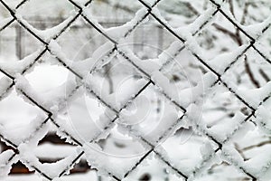 The grid of metal slabs is covered with snow.